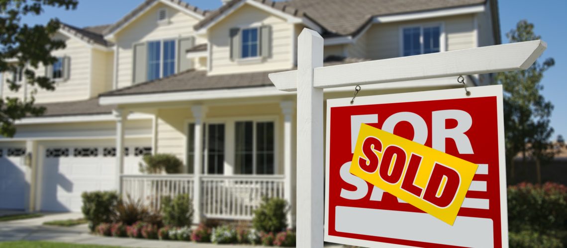 Sold Home For Sale Sign in Front of Beautiful New House.